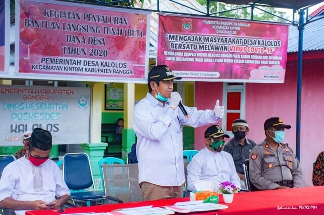 Foto Bupati Banggai H. Herwin Yatim saat menghadiri kegiatan penyaluran Bantuan Langsung Tunai kepada 107 orang Penerima BLT di Desa Kalolos, Juma't (1/5/2020). 